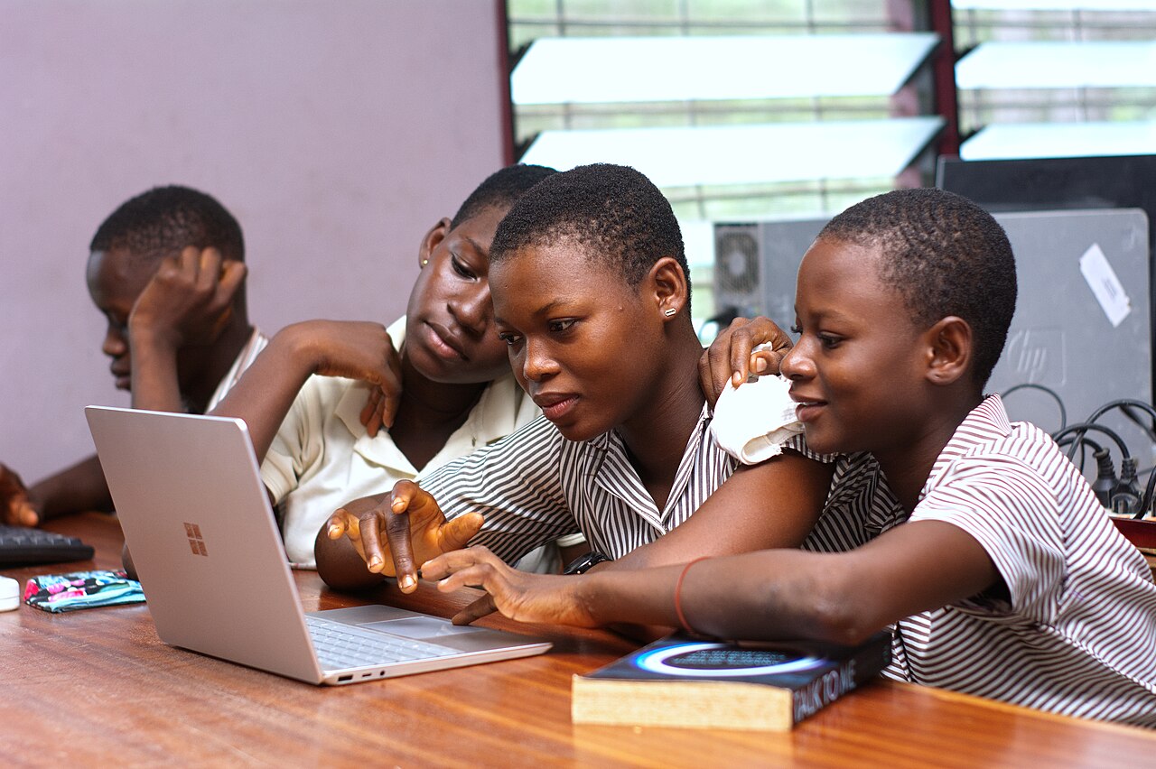 Ghanaian students learning together with a laptop in a classroom
